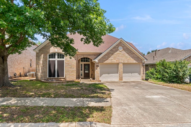8807 Brae Crst, San Antonio, TX 78249 - view of front of home featuring an attached garage, driveway, brick siding, and roof with shingles