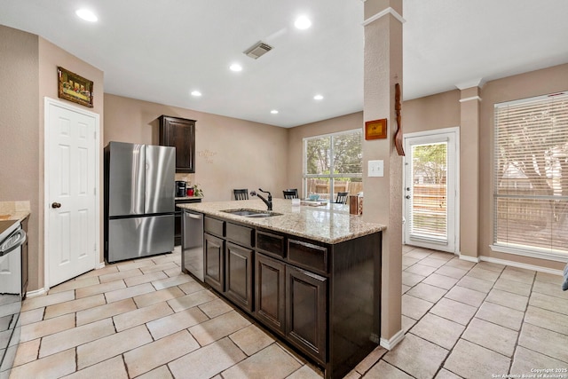 8807 Brae Crst, San Antonio, TX 78249 - kitchen featuring appliances with stainless steel finishes, a sink, ornate columns, light tile patterned floors, and dark brown cabinetry