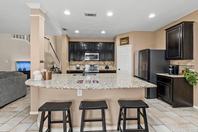 8807 Brae Crst, San Antonio, TX 78249 - kitchen featuring appliances with stainless steel finishes, decorative backsplash, a kitchen bar, and recessed lighting
