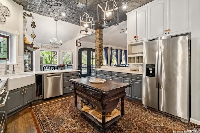 111 Kendall Oaks, Boerne, TX 78006 - kitchen featuring stainless steel appliances, gray cabinets, a sink, backsplash, and vaulted ceiling