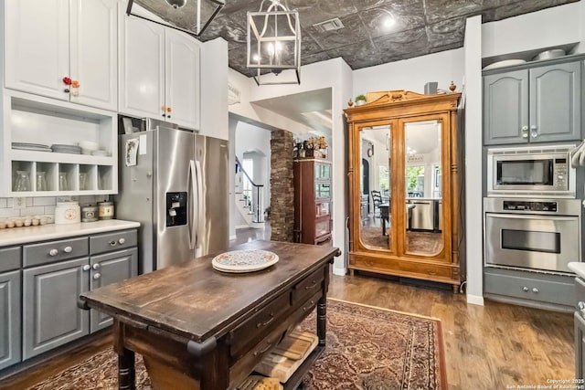 111 Kendall Oaks, Boerne, TX 78006 - kitchen featuring appliances with stainless steel finishes, an ornate ceiling, gray cabinets, dark wood-style flooring, and light countertops