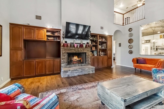 111 Kendall Oaks, Boerne, TX 78006 - living area with a towering ceiling, wood finished floors, arched walkways, a fireplace, and baseboards