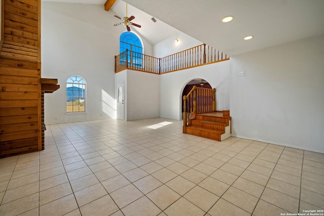 714 N Carroll, Poth, TX 78147 - unfurnished living room with stairs, ceiling fan, beam ceiling, light tile patterned flooring, and high vaulted ceiling