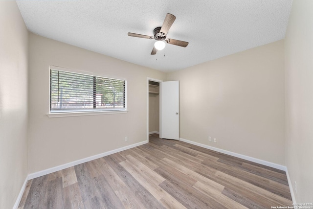 11302 Cedar Park, San Antonio, TX 78249 - unfurnished bedroom featuring wood finished floors, a textured ceiling, baseboards, a closet, and ceiling fan