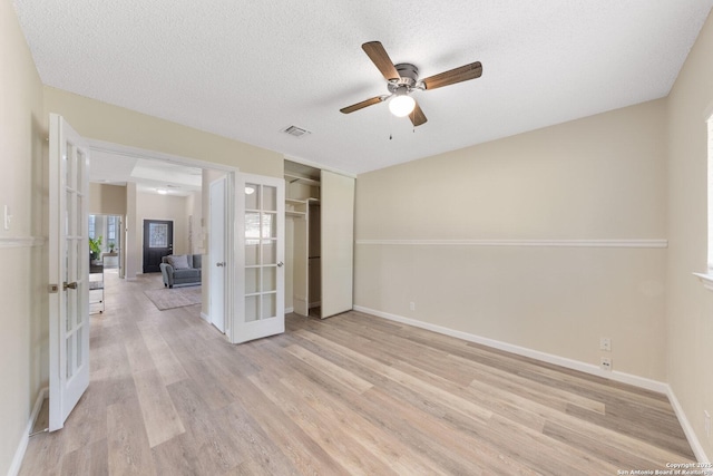 11302 Cedar Park, San Antonio, TX 78249 - unfurnished bedroom with french doors, light wood-style flooring, a closet, baseboards, and a textured ceiling
