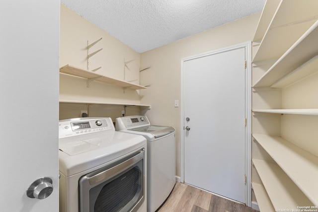 11302 Cedar Park, San Antonio, TX 78249 - washroom featuring independent washer and dryer, light wood-type flooring, and a textured ceiling