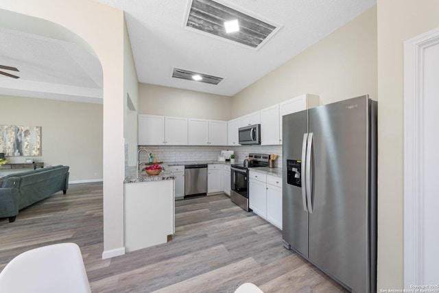 11302 Cedar Park, San Antonio, TX 78249 - kitchen with stainless steel appliances, open floor plan, white cabinets, light wood-style flooring, and a ceiling fan