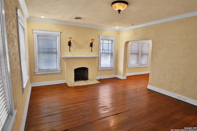1919 W Magnolia Ave, San Antonio, TX 78201 - unfurnished living room with a textured wall, crown molding, wood finished floors, a fireplace with raised hearth, and baseboards