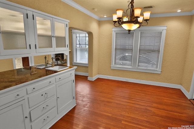 1919 W Magnolia Ave, San Antonio, TX 78201 - dining area with crown molding, baseboards, arched walkways, dark wood-type flooring, and a chandelier