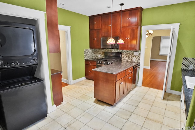 1919 W Magnolia Ave, San Antonio, TX 78201 - kitchen featuring stainless steel microwave, range with gas cooktop, estacked washer and dryer, dark countertops, and light tile patterned floors