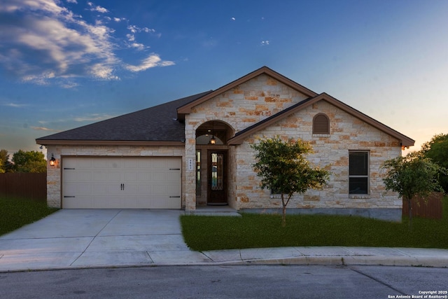 4862 Blue Jasmin, San Antonio, TX 78245 - view of front of house featuring an attached garage, driveway, stone siding, and a shingled roof