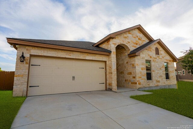 4862 Blue Jasmin, San Antonio, TX 78245 - view of front of house featuring stone siding, driveway, a garage, and a shingled roof