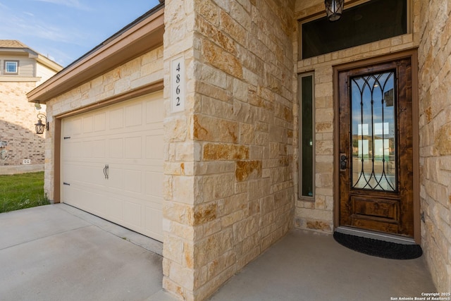 4862 Blue Jasmin, San Antonio, TX 78245 - doorway to property featuring stone siding, a garage, and driveway