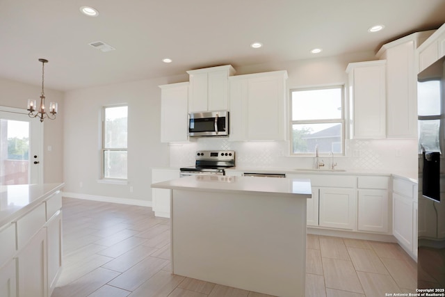 4862 Blue Jasmin, San Antonio, TX 78245 - kitchen with stainless steel appliances, a sink, backsplash, a chandelier, and recessed lighting