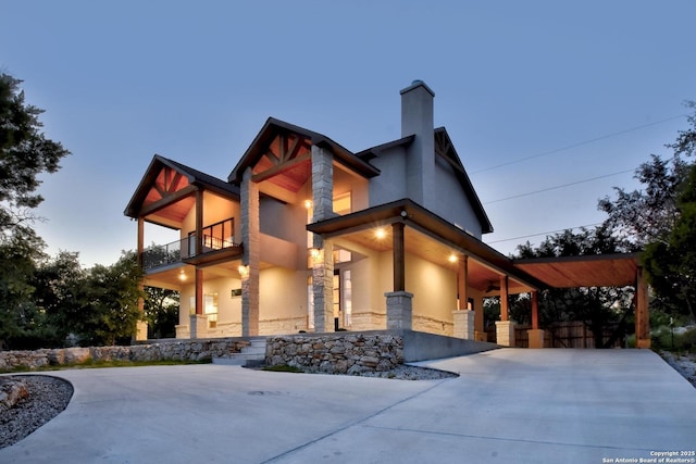 2191 Grandview Frst, Canyon Lake, TX 78133 - modern home with a balcony, stone siding, stucco siding, a chimney, and a porch