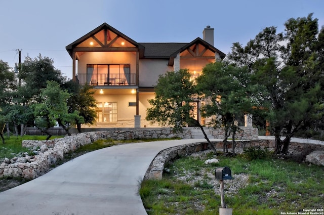 2191 Grandview Frst, Canyon Lake, TX 78133 - view of front of house featuring a balcony, stucco siding, and a chimney