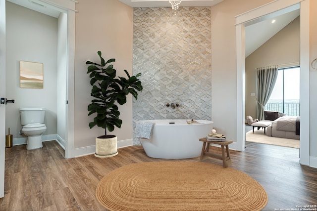 2191 Grandview Frst, Canyon Lake, TX 78133 - full bath featuring an accent wall, baseboards, a freestanding bath, toilet, and wallpapered walls