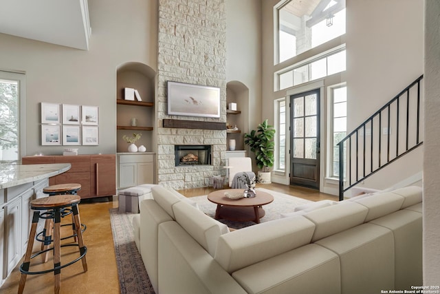 2191 Grandview Frst, Canyon Lake, TX 78133 - living area with a towering ceiling, built in features, a fireplace, and stairs