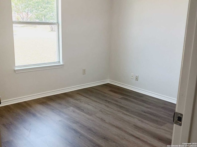 8610 James, Somerset, TX 78069 - empty room with dark wood-style flooring, healthy amount of natural light, and baseboards