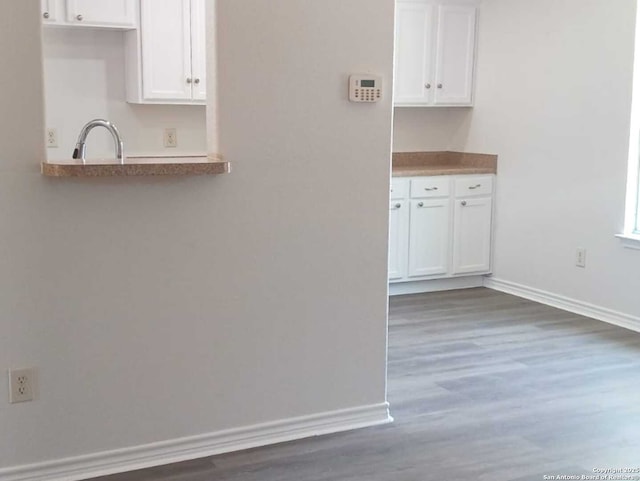 8610 James, Somerset, TX 78069 - kitchen featuring white cabinetry, dark wood-style flooring, and baseboards