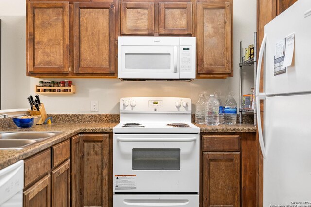 17 Oak Plz, San Antonio, TX 78216 - kitchen with white appliances, brown cabinetry, and a sink