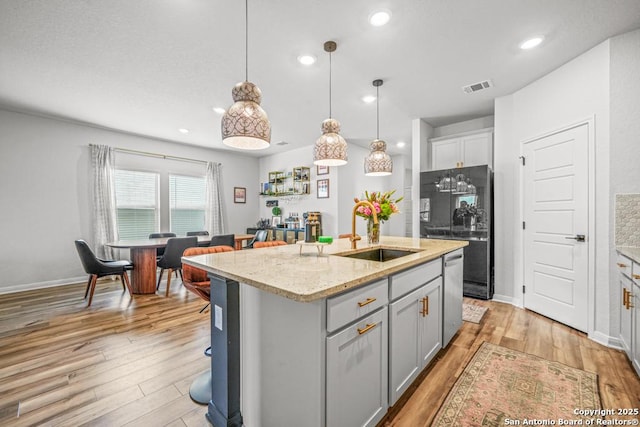 25826 Marigold Oaks, Boerne, TX 78006 - kitchen featuring a sink, freestanding refrigerator, light wood-style flooring, a kitchen island with sink, and dishwasher