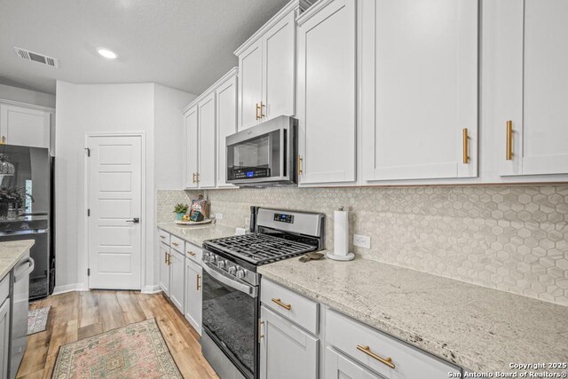 25826 Marigold Oaks, Boerne, TX 78006 - kitchen with appliances with stainless steel finishes, light wood-style floors, white cabinets, tasteful backsplash, and recessed lighting