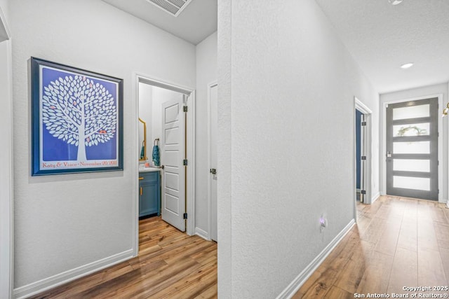 25826 Marigold Oaks, Boerne, TX 78006 - hall featuring a textured wall, wood finished floors, baseboards, and a textured ceiling