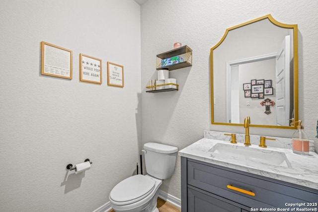 25826 Marigold Oaks, Boerne, TX 78006 - half bath with toilet, vanity, a textured wall, baseboards, and wood finished floors