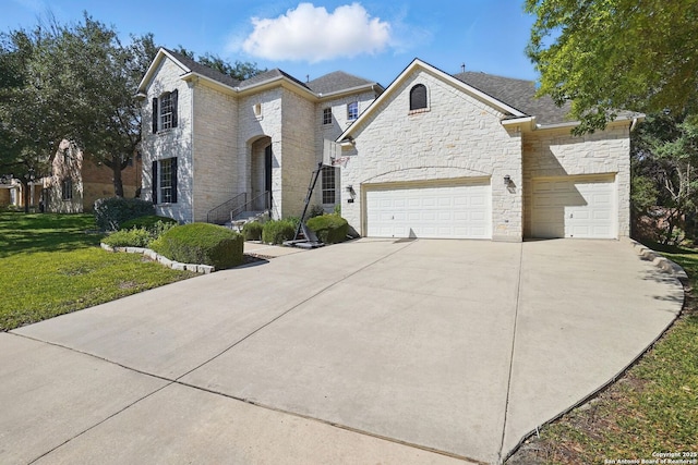 51 Stonewall Bnd, San Antonio, TX 78256 - french country inspired facade featuring stone siding, driveway, a front yard, and an attached garage
