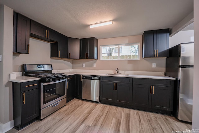 312 Avondale, San Antonio, TX 78223 - kitchen with appliances with stainless steel finishes, a sink, light wood finished floors, light countertops, and a textured ceiling