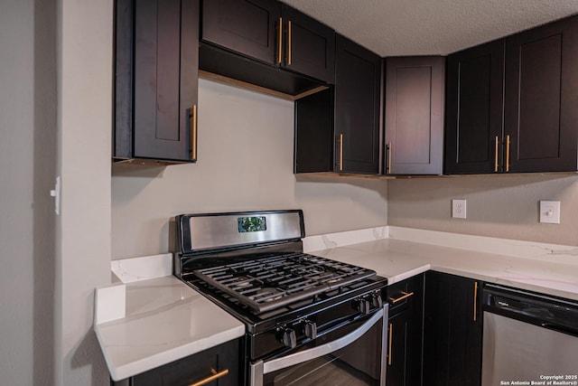 312 Avondale, San Antonio, TX 78223 - kitchen featuring appliances with stainless steel finishes, a textured ceiling, light stone counters, and dark cabinets