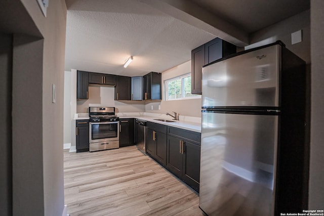 312 Avondale, San Antonio, TX 78223 - kitchen featuring stainless steel appliances, a sink, light countertops, light wood finished floors, and a textured ceiling