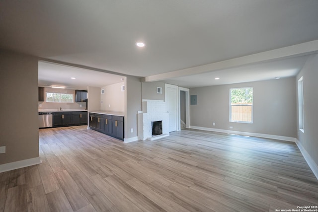 312 Avondale, San Antonio, TX 78223 - unfurnished living room with plenty of natural light, light wood-style flooring, a fireplace, baseboards, and recessed lighting