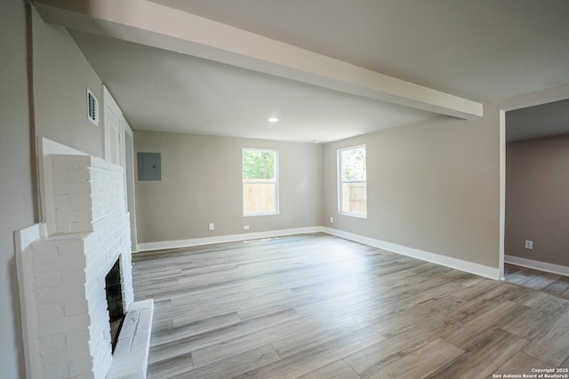 312 Avondale, San Antonio, TX 78223 - unfurnished living room featuring light wood-style flooring, a brick fireplace, baseboards, electric panel, and recessed lighting