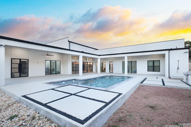 1356 Capitare, New Braunfels, TX 78132 - back of property at dusk with a patio, a ceiling fan, an outdoor pool, and stucco siding