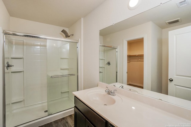 237 Corliss, San Antonio, TX 78220 - full bathroom with a stall shower, wood finished floors, a walk in closet, and vanity