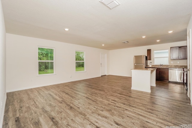 237 Corliss, San Antonio, TX 78220 - unfurnished living room featuring wood finished floors, healthy amount of natural light, recessed lighting, and a sink