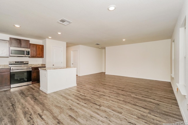 237 Corliss, San Antonio, TX 78220 - kitchen with appliances with stainless steel finishes, light wood-type flooring, open floor plan, recessed lighting, and a kitchen island