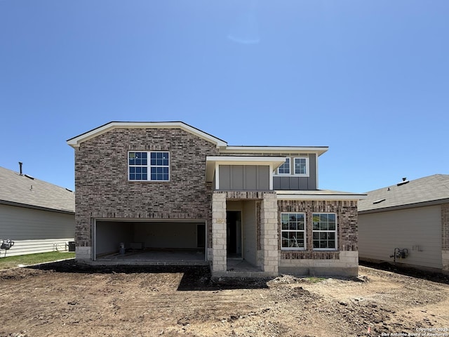 14724 Sycamore Xing, San Antonio, TX 78252 - view of front of property with driveway, board and batten siding, an attached garage, and brick siding