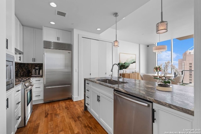 610 E Market St Unit 3110, San Antonio, TX 78205 - kitchen with built in appliances, a sink, tasteful backsplash, white cabinets, and dark wood-type flooring