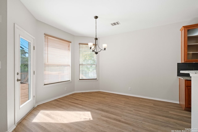 17223 Darlington Run, San Antonio, TX 78247 - unfurnished dining area with a chandelier, light wood finished floors, healthy amount of natural light, and baseboards