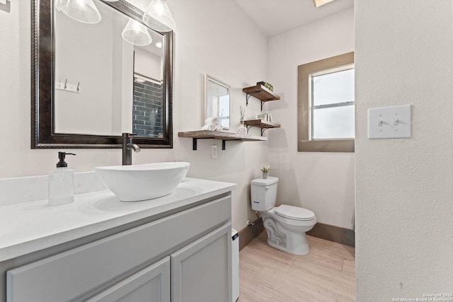 631 Muncey St, San Antonio, TX 78202 - bathroom with toilet, vanity, baseboards, and wood finished floors