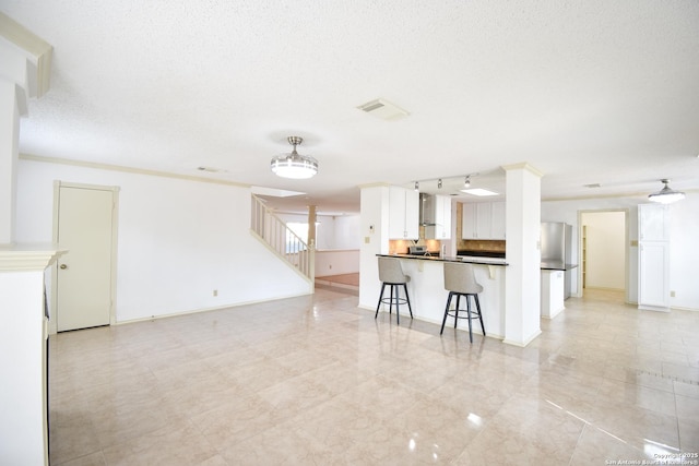 15850 Marisa Pl, San Antonio, TX 78247 - kitchen featuring open floor plan, a kitchen breakfast bar, white cabinets, dark countertops, and a peninsula