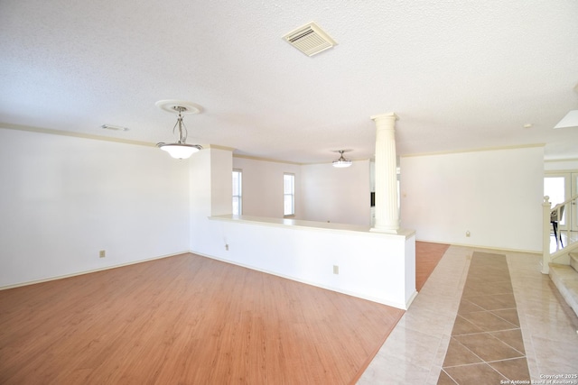 15850 Marisa Pl, San Antonio, TX 78247 - empty room with ornate columns, a textured ceiling, stairway, and wood finished floors