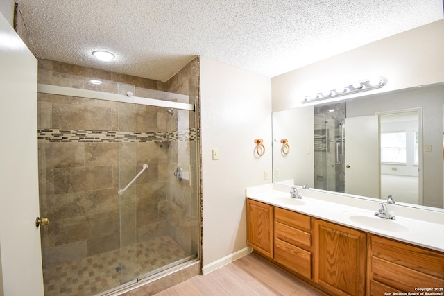 15850 Marisa Pl, San Antonio, TX 78247 - full bath featuring a textured ceiling, a shower stall, double vanity, and wood finished floors