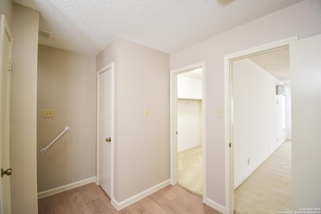 15850 Marisa Pl, San Antonio, TX 78247 - corridor featuring light wood-style floors, a textured ceiling, baseboards, and an upstairs landing