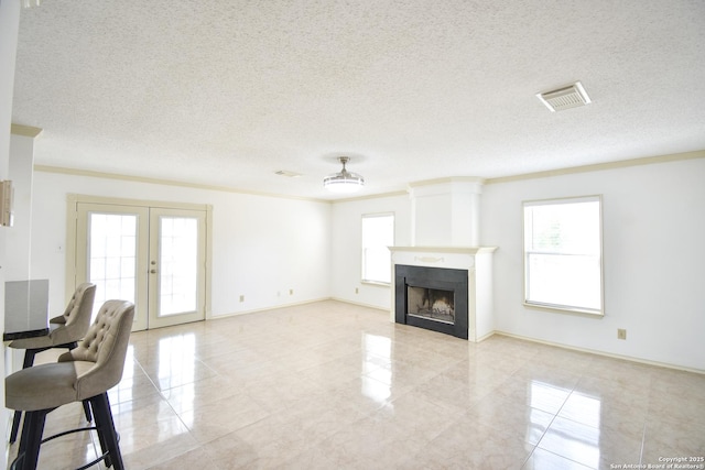 15850 Marisa Pl, San Antonio, TX 78247 - unfurnished living room featuring french doors, a textured ceiling, light tile patterned flooring, a fireplace, and ornamental molding
