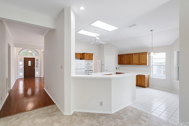 4635 Shavano Birch, San Antonio, TX 78230 - kitchen with white appliances, vaulted ceiling, brown cabinetry, light countertops, and a peninsula