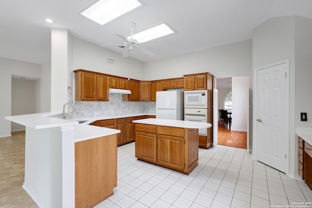 4635 Shavano Birch, San Antonio, TX 78230 - kitchen with white appliances, a sink, ceiling fan, under cabinet range hood, and a peninsula